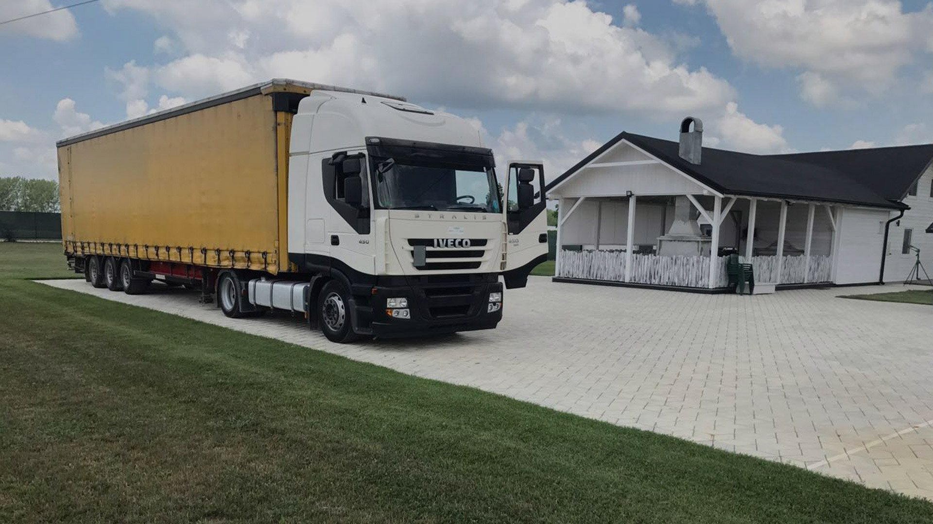 Iveco tegljač sa žutom ceradnom prikolicom